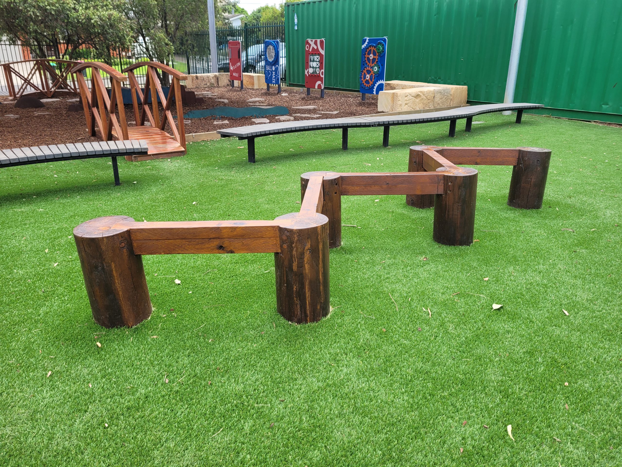 Balance beam installed on synthetic grass in an outdoor playground
