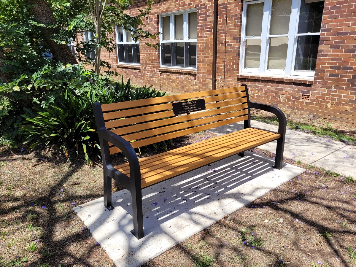 Seat with Memorial plaque under the shade of a tree